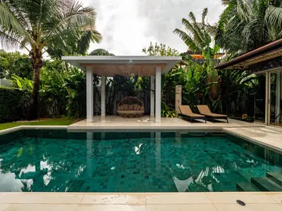 a swimming pool with two chairs and a gazebo at Exclusive Villa Botanica in Bang Tao Beach
