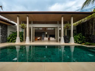 a swimming pool in front of a house at Exclusive Villa Botanica in Bang Tao Beach