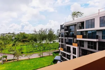 an apartment building with a park in the background at Laguna SkyPark new brand apartments in Phuket Town