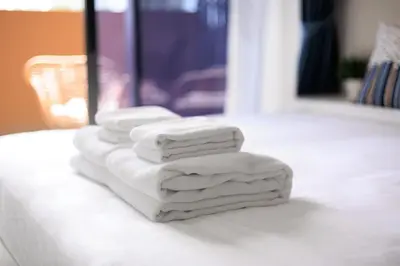four towels stacked on top of a white table at Laguna SkyPark new brand apartments in Phuket Town