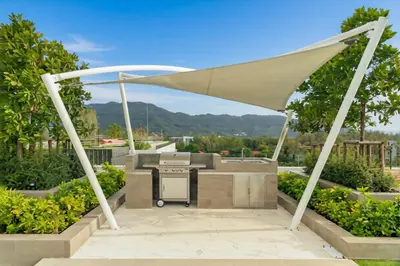 a picnic table under a canopy in a garden at Laguna SkyPark new brand apartments in Phuket Town