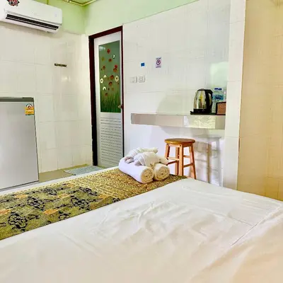 a bedroom with a bed with towels on it at Chamil House (ชามิล เฮ้าส์) in Ban Ko En