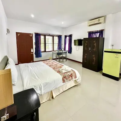 a bedroom with a large bed and a kitchen at Chamil House (ชามิล เฮ้าส์) in Ban Ko En