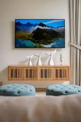 a living room with two blue chairs and a tv at 3-Bedroom Pool Villa in Trichada Sky at Bangtao in Bang Tao Beach