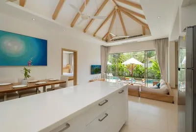 an open kitchen and living room with a view of the ocean at 3-Bedroom Pool Villa in Trichada Sky at Bangtao in Bang Tao Beach