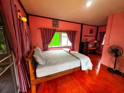 a bedroom with a bed in a room with red walls at Kanitta Homestay kohyaonoi in Ban Bang Chak
