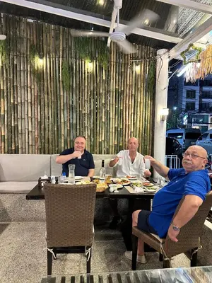 a group of men sitting at a table eating food at Istanbul Boutique Hotel in Patong Beach