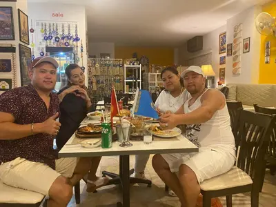 a group of people sitting around a table eating food at Istanbul Boutique Hotel in Patong Beach