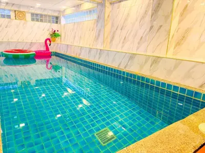 a swimming pool with a red swan in the water at Orchid Pool Villa - SHA Extra Plus - indoor Warm pool in Phuket Town