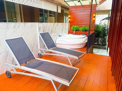 two folding chairs on a deck with a bath tub at Orchid Pool Villa - SHA Extra Plus - indoor Warm pool in Phuket Town