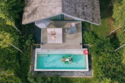 an overhead view of a person swimming in a pool at Villa Escape Burasari in Phuket Town