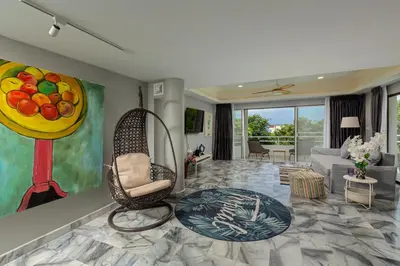 a living room with a chair and a painting of fruit at 5BR Jungle Seaview Villa Patong in Patong Beach