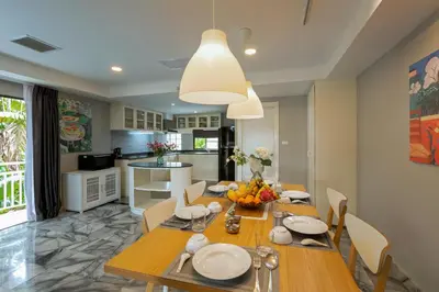 a dining room with a table and a kitchen at 5BR Jungle Seaview Villa Patong in Patong Beach