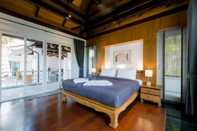 a bedroom with a bed and a large window at Luxurious Residence Rawai in Phuket Town