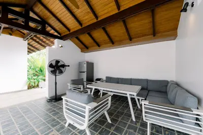 a patio with a couch and a table and chairs at Luxurious Residence Rawai in Phuket Town