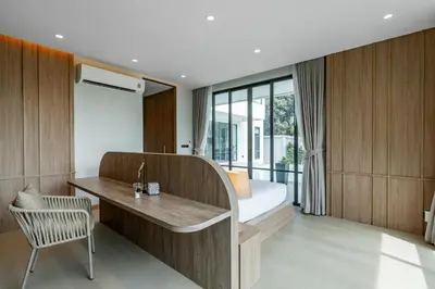 a bedroom with a bed and a desk with a chair at Aya Residence Garden View in Ban Ket Ho