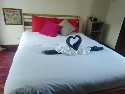 a white bed with a heart decoration on it at Banpoo in Ko Yao Noi