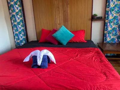 two stuffed animals on a bed with red sheets at Banpoo in Ko Yao Noi