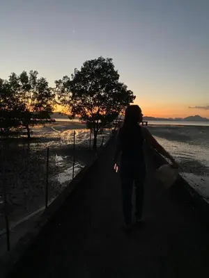 a woman walking down a sidewalk at sunset at Banpoo in Ko Yao Noi