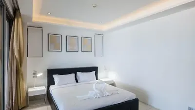 a bedroom with a bed with a white blanket at The Kata View Phuket apartment in Kata Beach