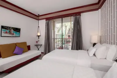 a white bedroom with two beds and a couch at THE TOP PATONG RESORT. in Patong Beach