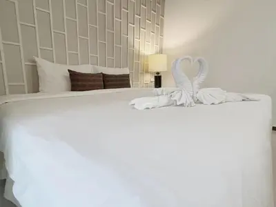 a white bed with a heart decoration on it at THE TOP PATONG RESORT. in Patong Beach