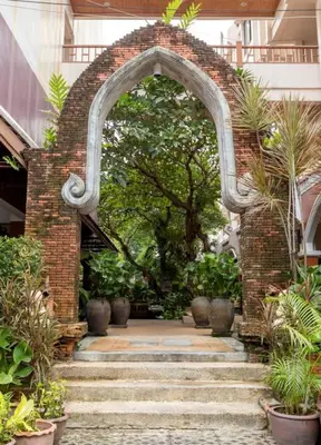 an archway in a building with stairs and plants at THE TOP PATONG RESORT. in Patong Beach