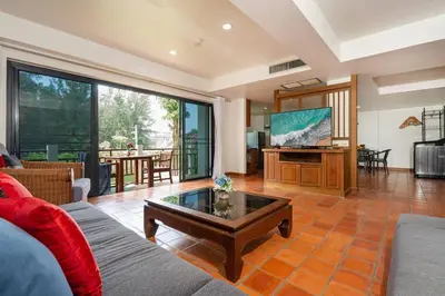 a living room with a couch and a tv at Beachside Apt Short Walk to Nai Harn Beach 2-3 BR in Nai Harn Beach