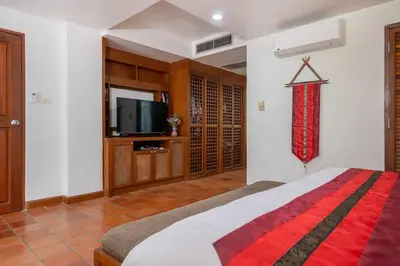 a bedroom with a bed and a flat screen tv at Beachside Apt Short Walk to Nai Harn Beach 2-3 BR in Nai Harn Beach