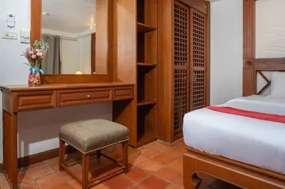 a bedroom with a bed and a desk with a mirror at Beachside Apt Short Walk to Nai Harn Beach 2-3 BR in Nai Harn Beach