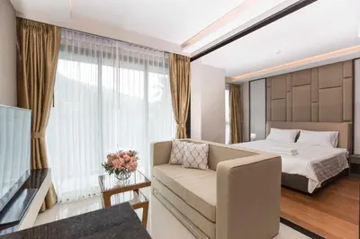a hotel room with a bed and a couch at The Panora apartments by NLA in Surin Beach