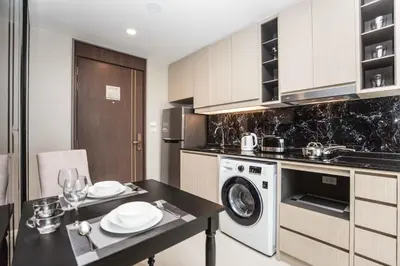 a kitchen with a table and a washing machine at The Panora apartments by NLA in Surin Beach