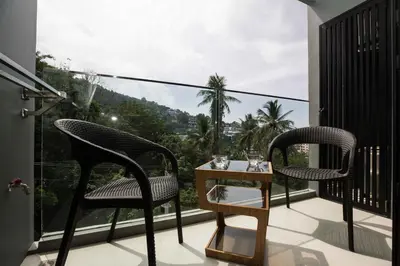 two chairs and a table on a balcony with a view at The Panora apartments by NLA in Surin Beach