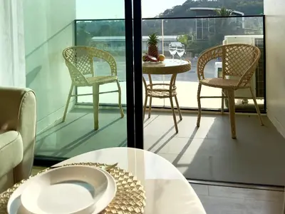 a balcony with two chairs and a table and a table and chairs at La Vita Phuket Rawai in Rawai Beach