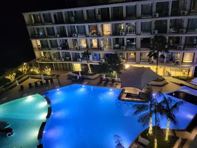 a large pool in front of a building at night at La Vita Phuket Rawai in Rawai Beach