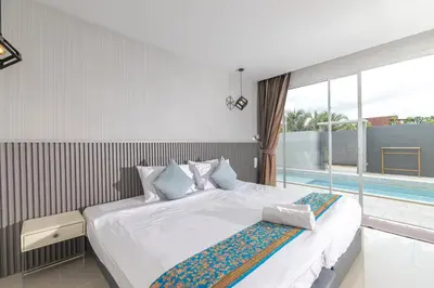 a bedroom with a large bed and a swimming pool at Andaman Sea Best Pool Access and Villas in Chalong