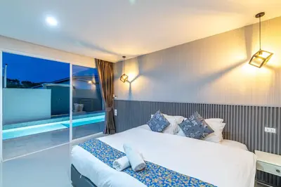 a hotel room with a bed and a swimming pool at Andaman Sea Best Pool Access and Villas in Chalong