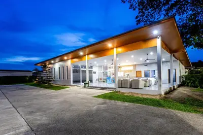 a large white house with lights on it at Andaman Sea Best Pool Access and Villas in Chalong