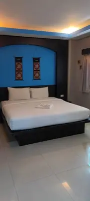 a bedroom with a large bed with a blue headboard at New Lavender Hotel Patong in Patong Beach