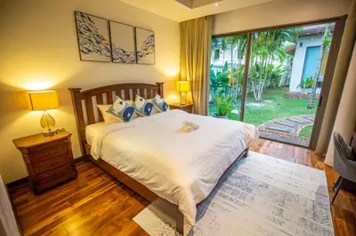 a bedroom with a bed and a sliding glass door at Phuket Boutique Pool Villa-81 in Rawai Beach