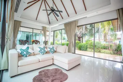 a living room with a white couch and large windows at Phuket Boutique Pool Villa-81 in Rawai Beach