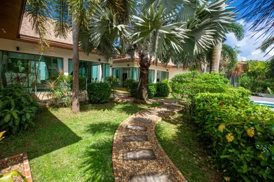 a garden with palm trees and a walkway at Phuket Boutique Pool Villa-81 in Rawai Beach