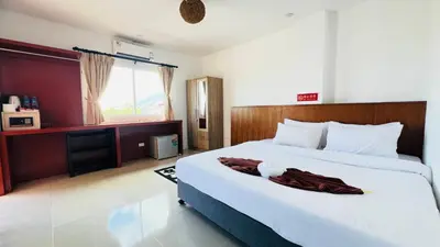 a bedroom with a large white bed and a window at Jasmin Guest House in Patong Beach