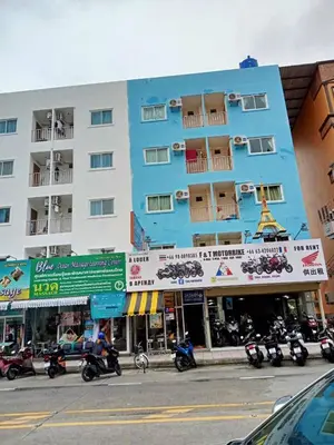 a large building with motorcycles parked in front of it at Jasmin Guest House in Patong Beach