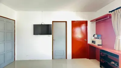 a room with two doors and a tv on a wall at Jasmin Guest House in Patong Beach