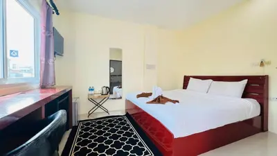 a bedroom with a large white bed and a window at Jasmin Guest House in Patong Beach