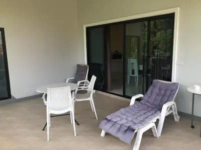 two chairs and a table with a purple cushion on a patio at M&N Guesthouse Kata in Kata Beach