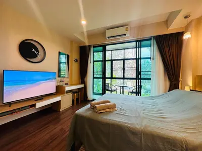 a bedroom with a bed with a flat screen tv at Brand Naithon Condo C411 in Nai Thon Beach