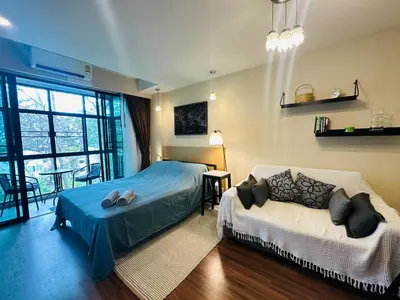 a bedroom with a bed and a couch and a window at Brand Naithon Condo C411 in Nai Thon Beach
