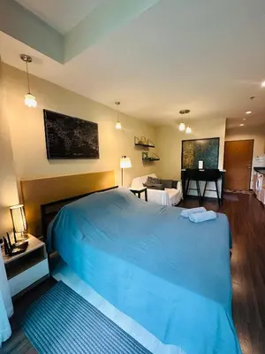 a bedroom with a large blue bed and a living room at Brand Naithon Condo C411 in Nai Thon Beach